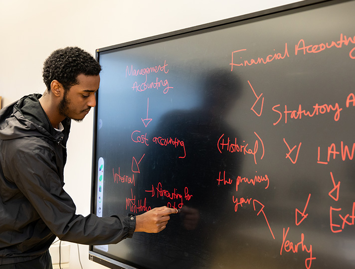 Student working at a wipe board in classroom